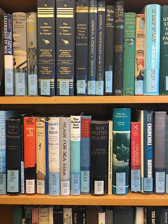 Roskill Library bookshelves with books on naval history