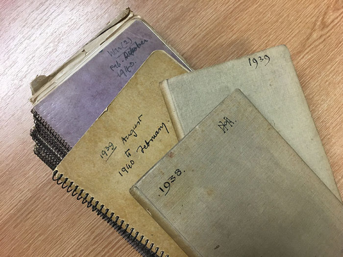 A stack of diaries. Those visible on top of the stack are dated from 1938-1940
