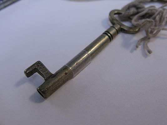 A close up of one of the keys, which has been secured to a card mount using a strip of clear polyethylene.