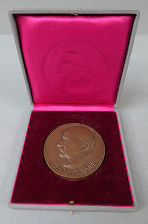 A medal in  a presentation box. Inscribed on the medal is the name Max Planck and the image of a man's head in profile.