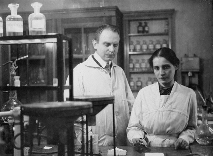 Black and white photograph of Lise Meitner and Otto Hahn working in a laboratory