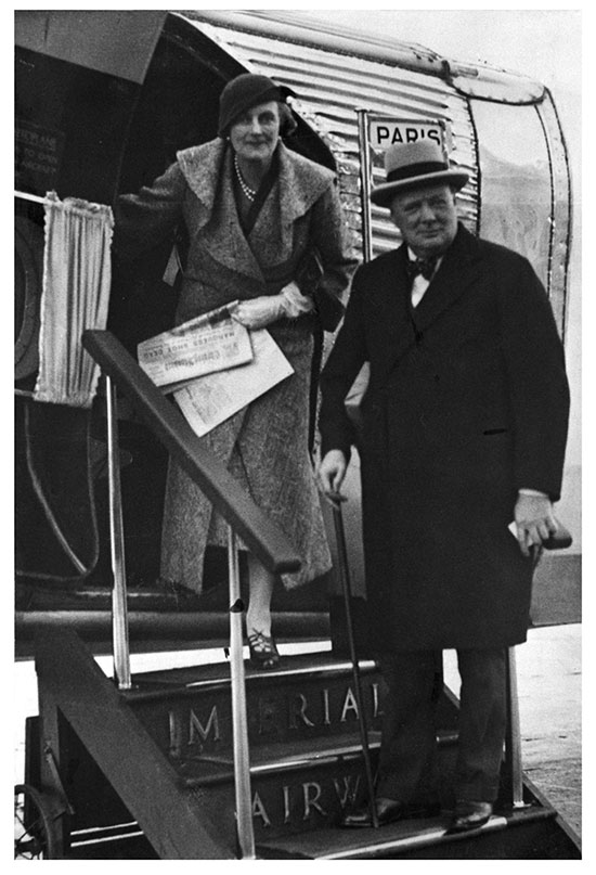 Black and white photo of Clementine and Winston Churchill, who are standing on the steps outside an aeroplane