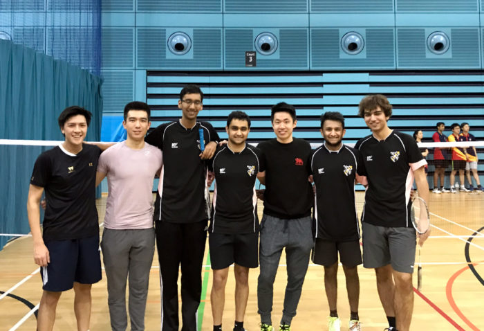 The Churchill badminton team standing together and smiling at the camera