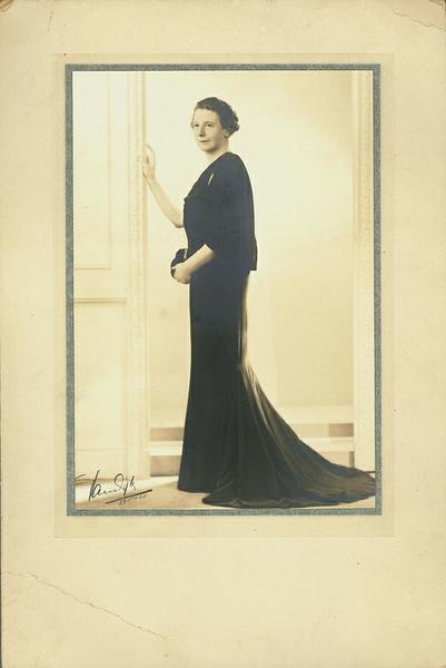 Florence Horsbrugh dressed in a formal evening gown with a train. 