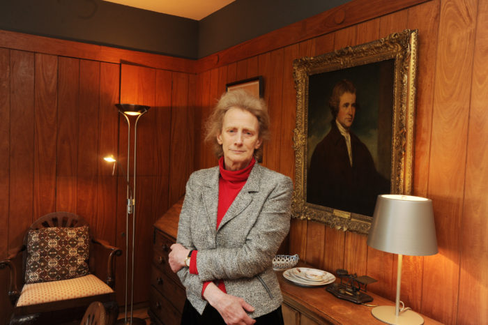 Athene Donald, Master of Churchill College, standing in a wood panelled room. She is looking at the camera with a serious expression