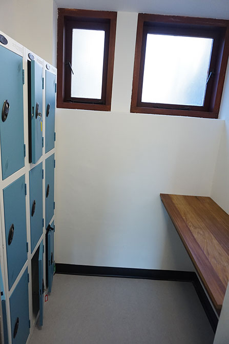 The new locker space in the Archives Centre. There is a bank of lockers on the left hand side of the room, and a table on the right hand side of the room.