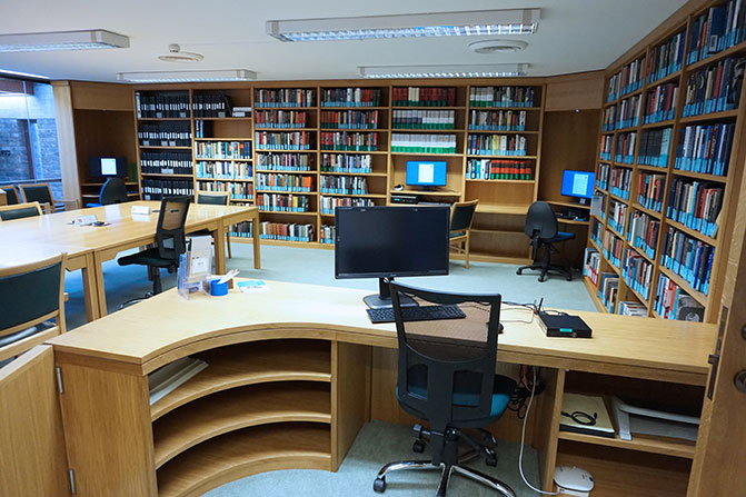 A view from the staff desk into the expanded reading room. There is an enlarged staff desk and a much larger study space for readers.