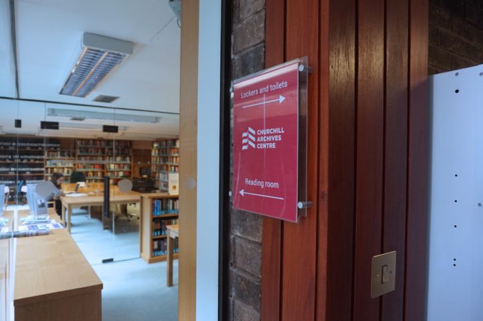 A glimpse into the Archives Centre reading room through the glass entrance door.