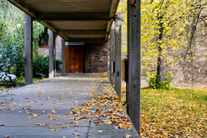 Covered walkway in the College grounds in autumn, with fallen leaves o the ground