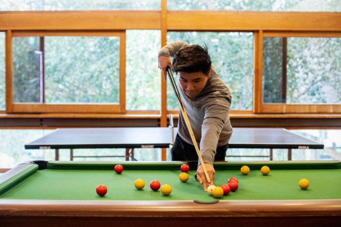 A male student playing pool in the Games Room