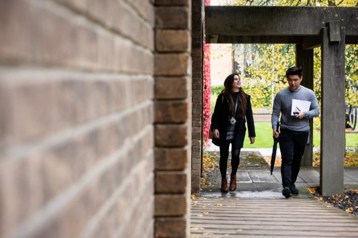 Female and male student walking in the College grounds.