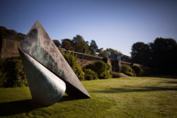 Large geometric sculpture on a lawn in a garden on a sunny day
