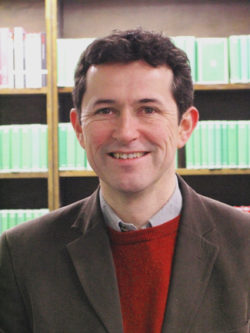 Profile photo of Jerry Toner. He stands in front of a bookshelf filled with green Loeb Classical Library books.