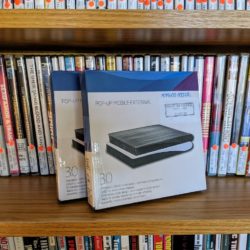 Two boxes containing portable DVD drives sit in front of a bookshelf full of DVDs