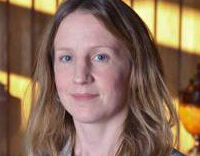 Profile photo of Dr Sally Boss. She is standing in a wood panelled room.