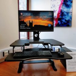 A computer monitor, mouse and keyboard on an adjustable workstation which can be raised or lowered.