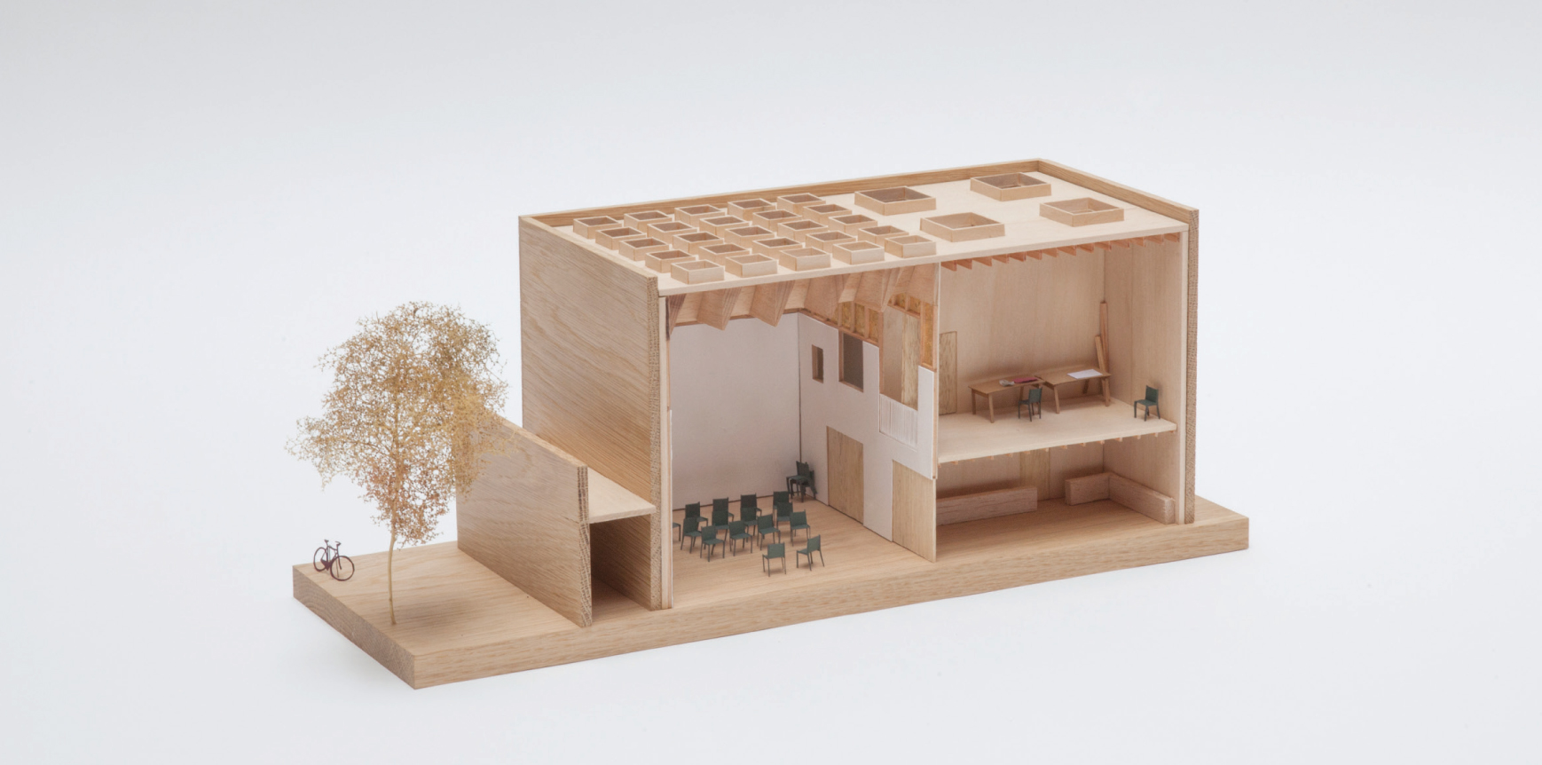 A wooden design model of the creative space. Half of the building is split over two storeys, the other half is a double height space