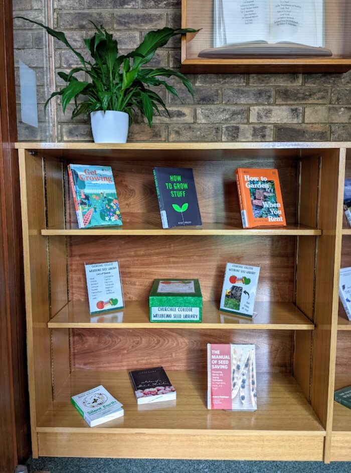 Bookshelves in the Bracken Library foyer where books about gardening are on display next to the box containing the seed library