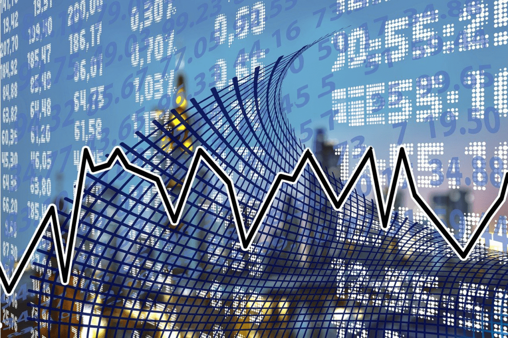 A digital representation of a fluctuating stock market graph overlaid on a background with numbers and a grid. The graph, an embodiment of economics in motion, shows peaks and valleys, symbolizing market changes. A cityscape with glowing lights is faintly visible in the background.