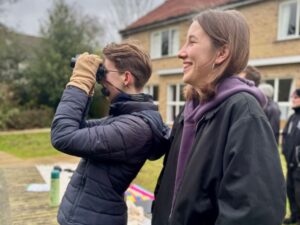 Two birdwatchers in the gardens of Churchill College